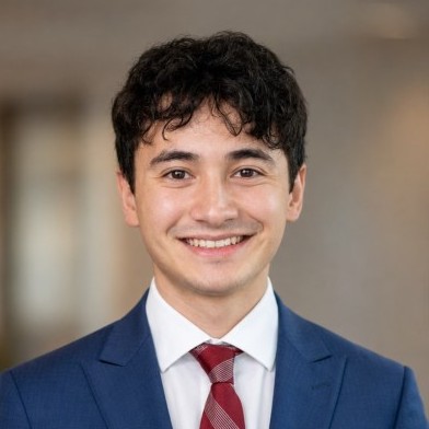 Professional headshot of Daniel R. Lombardi wearing a navy suit and red tie